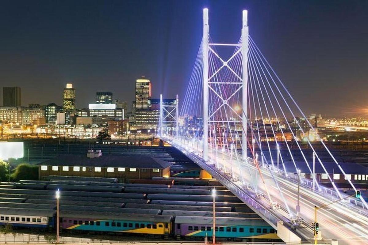 Un puente sobre una ciudad de noche con trenes.