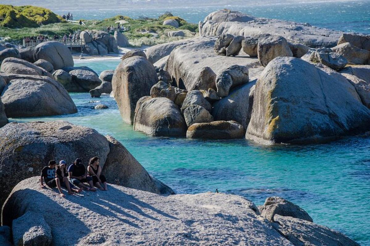 Un grupo de personas sentadas sobre rocas en el agua.
