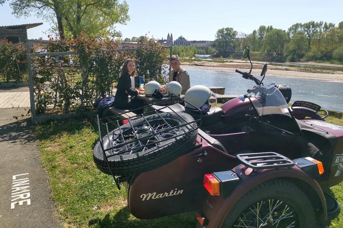 a man and a woman sitting next to a motorcycle