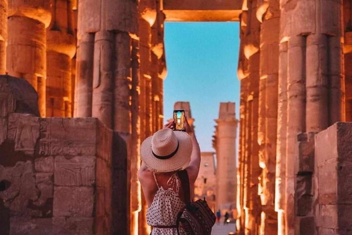 a woman taking a picture of the ruins of a building