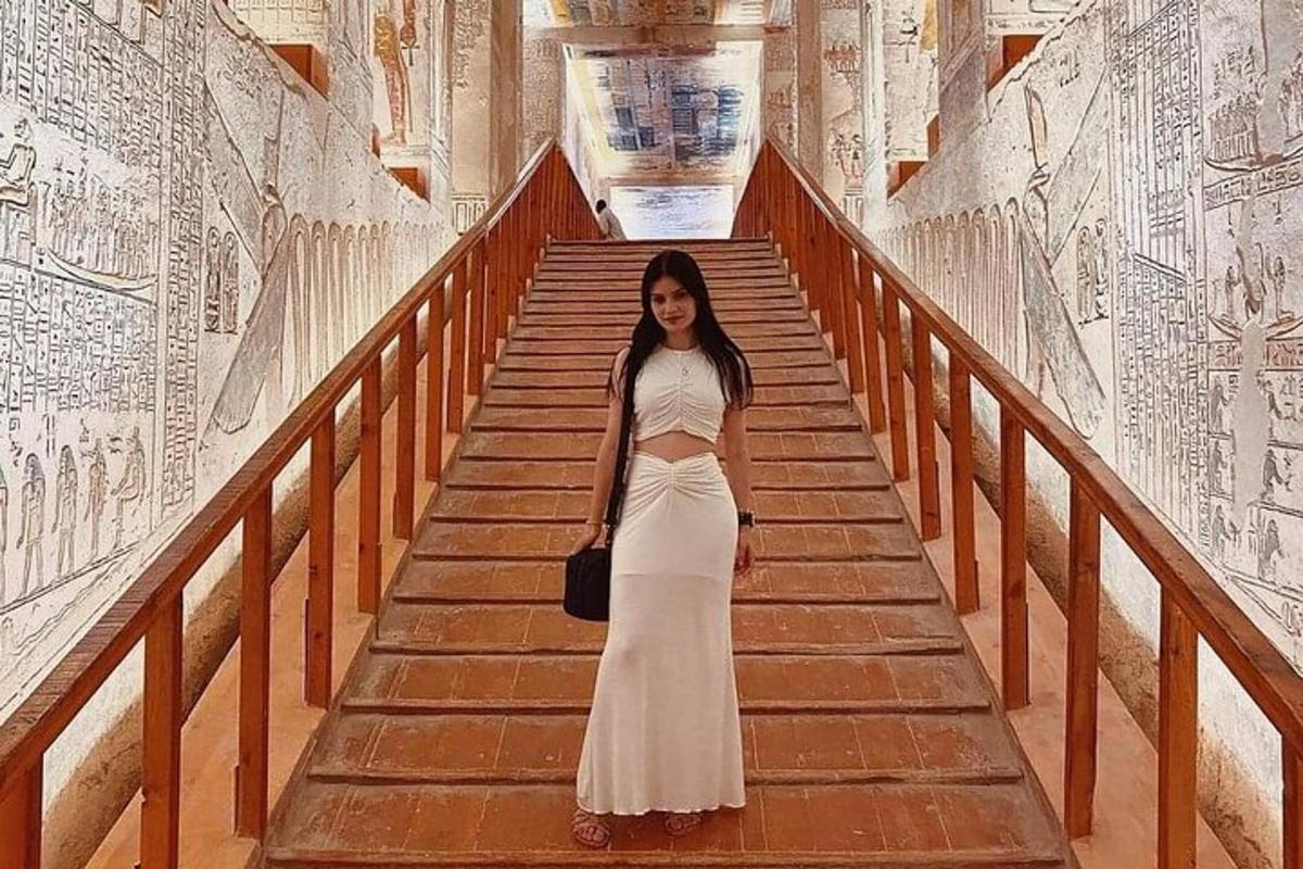 a woman in a white dress walking down some stairs