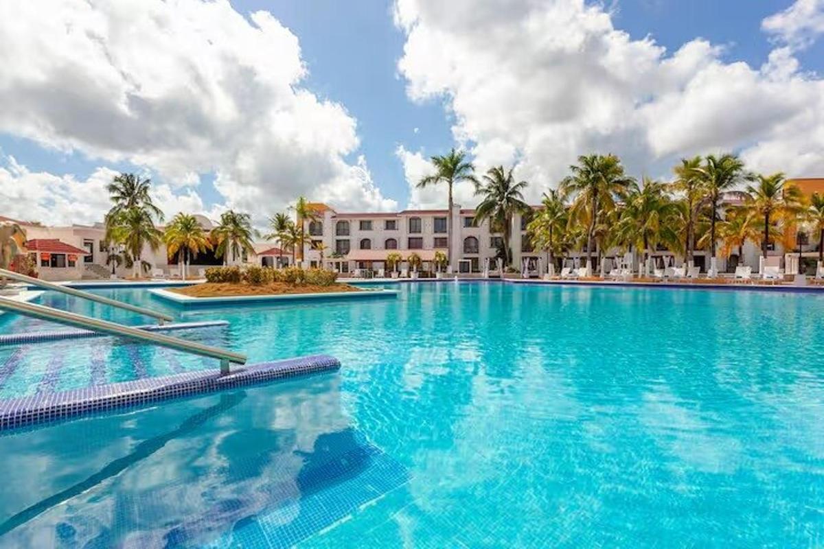 uma grande piscina com palmeiras e um edifício