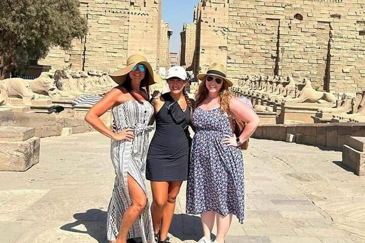 три женщины позируют для фотографии перед зданием