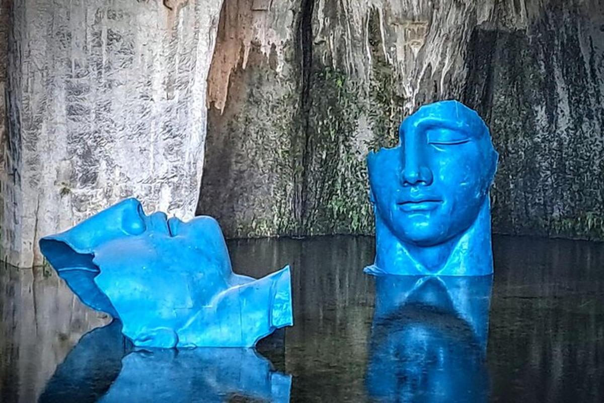 una estatua azul en el agua junto a una pared