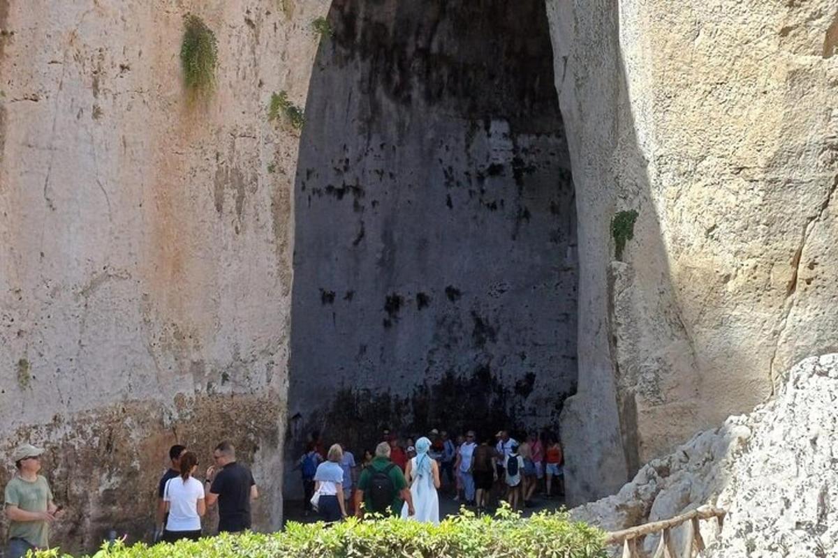μια ομάδα ανθρώπων που περπατούν μέσα από μια σήραγγα σε έναν τοίχο