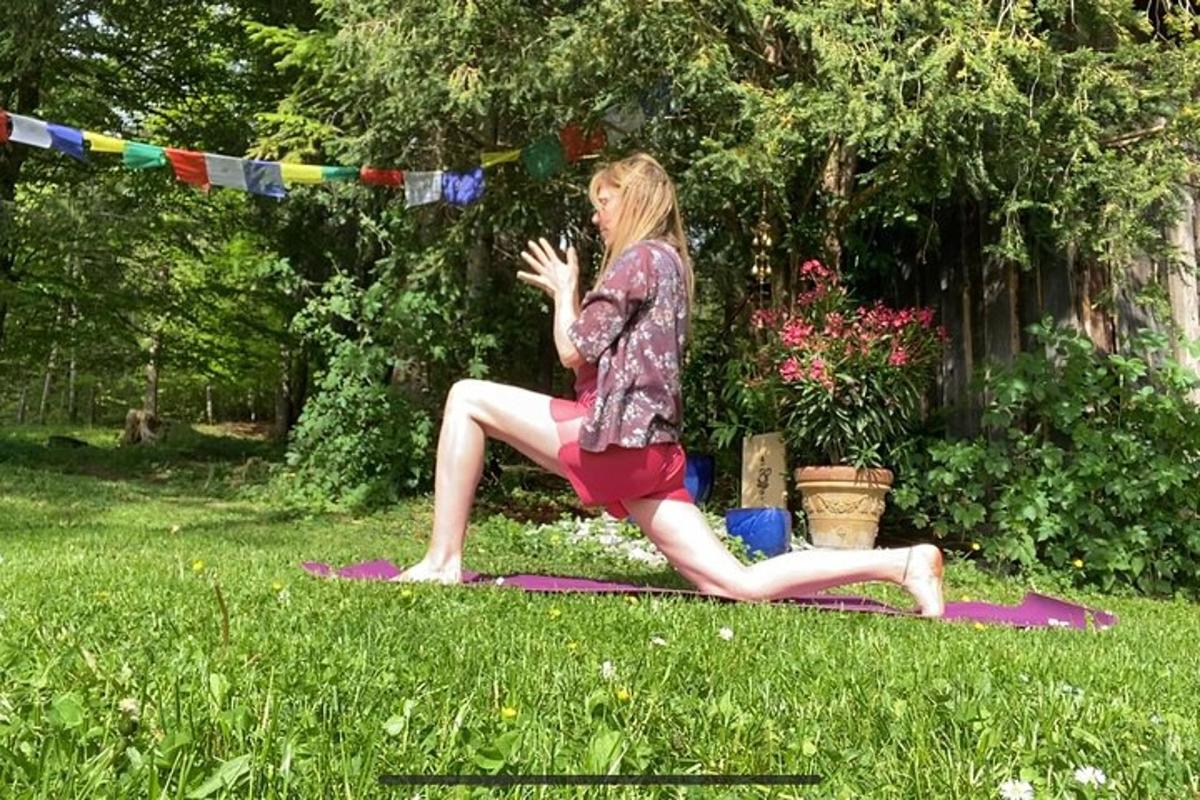 a woman doing a yoga pose in the grass