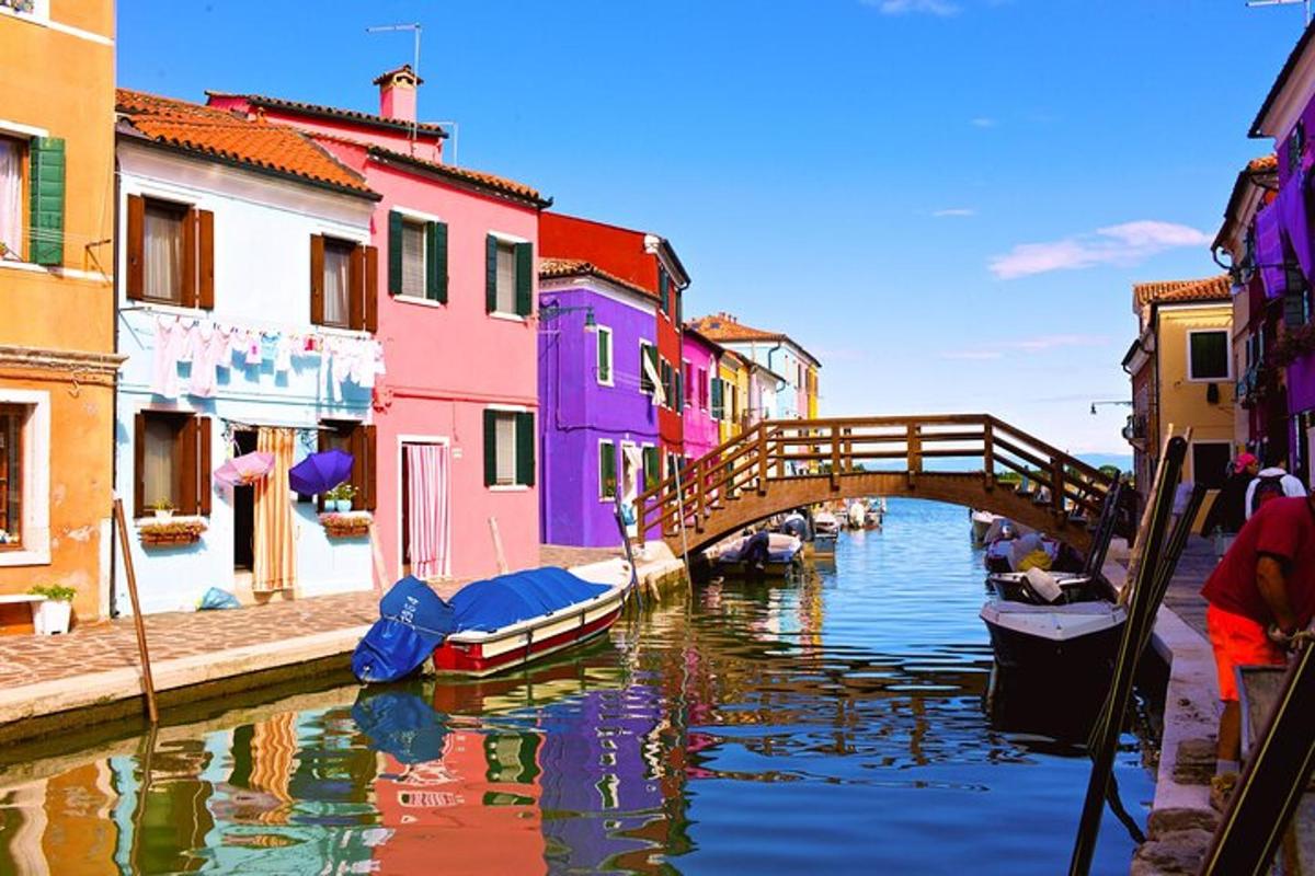 un pont sobre un canal amb cases i vaixells de colors