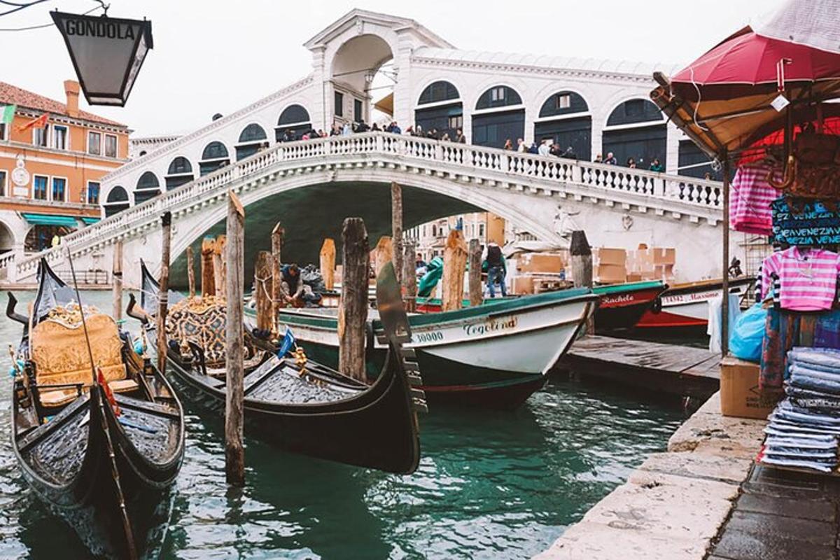 un gruppo di gondole in acqua sotto un ponte