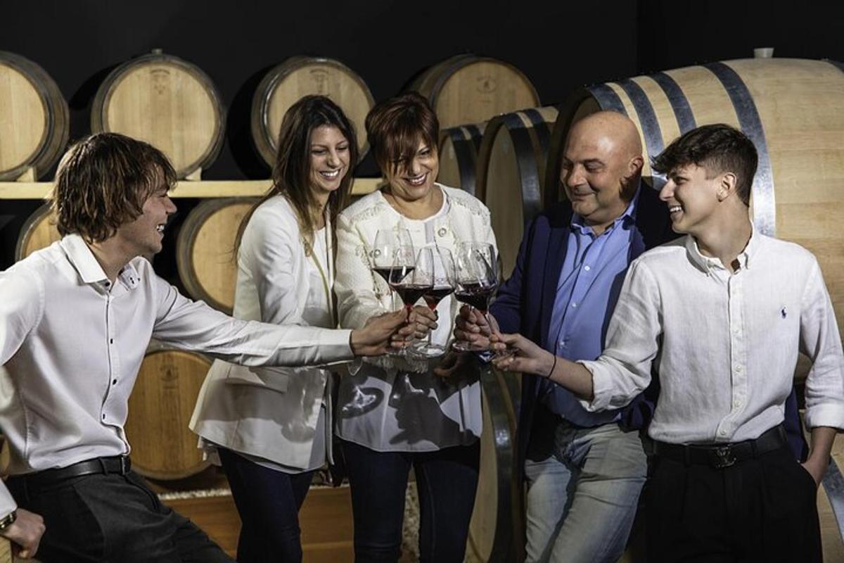 skupina lidí držících sklenice na víno ve vinném sklepě