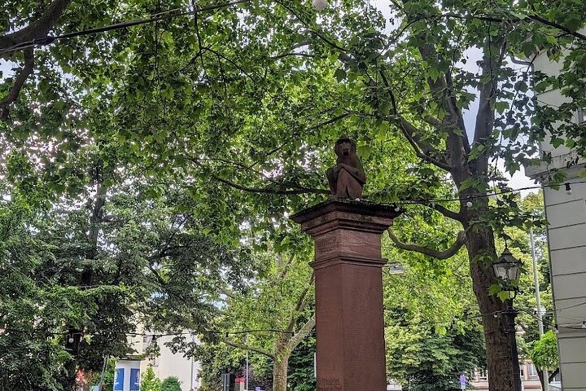 socha sedící na vrcholu tyče v parku