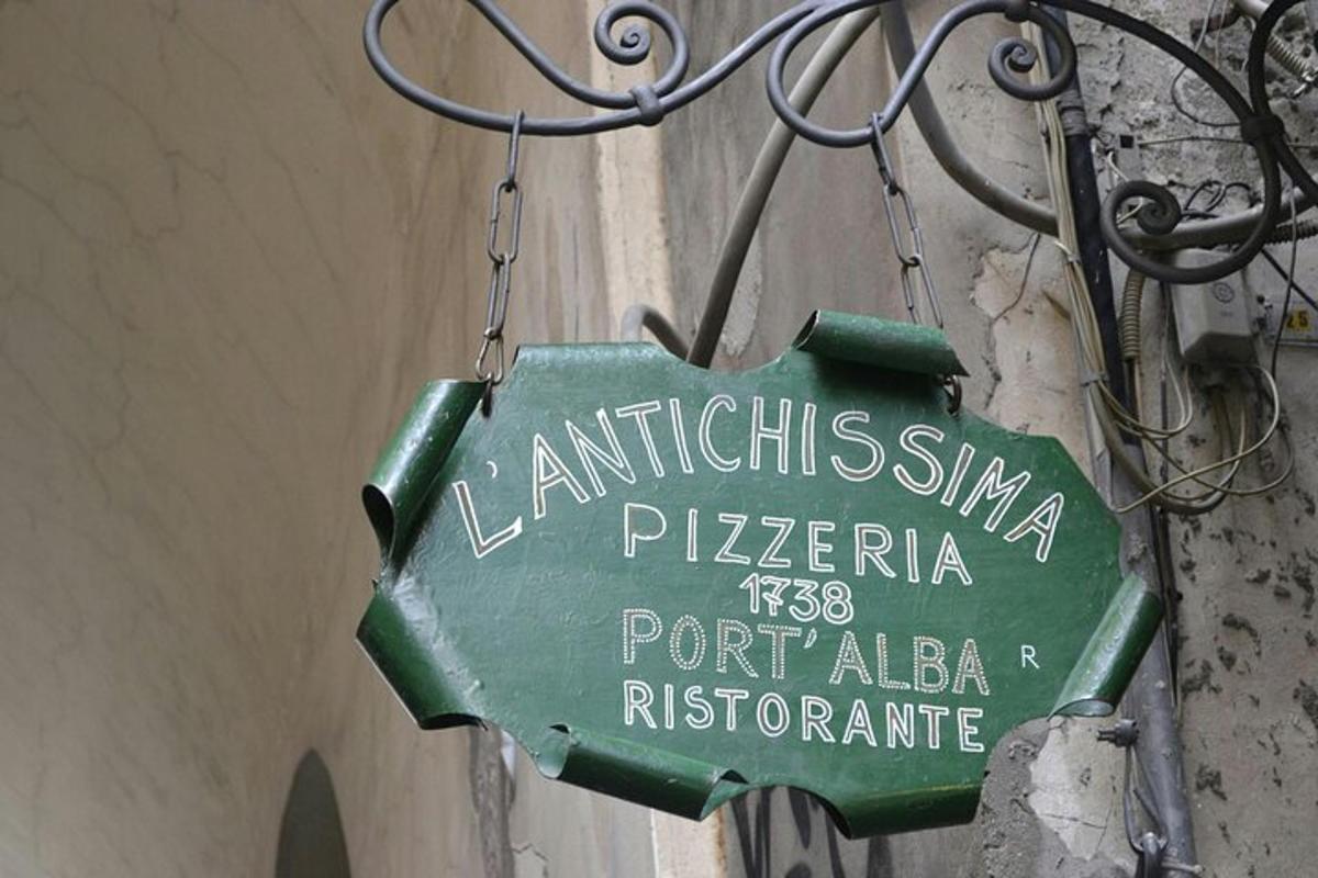 un cartello verde attaccato a un muro con un cartello