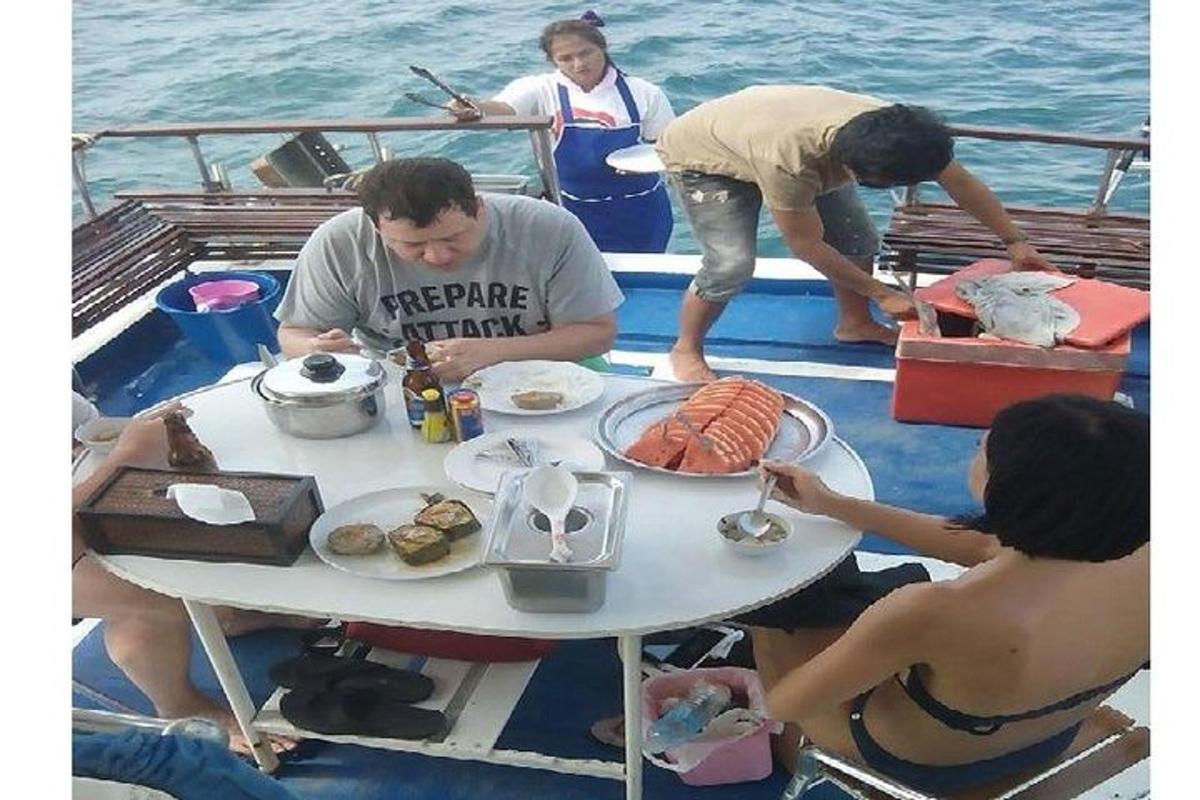 skupina lidí sedících kolem stolu na lodi