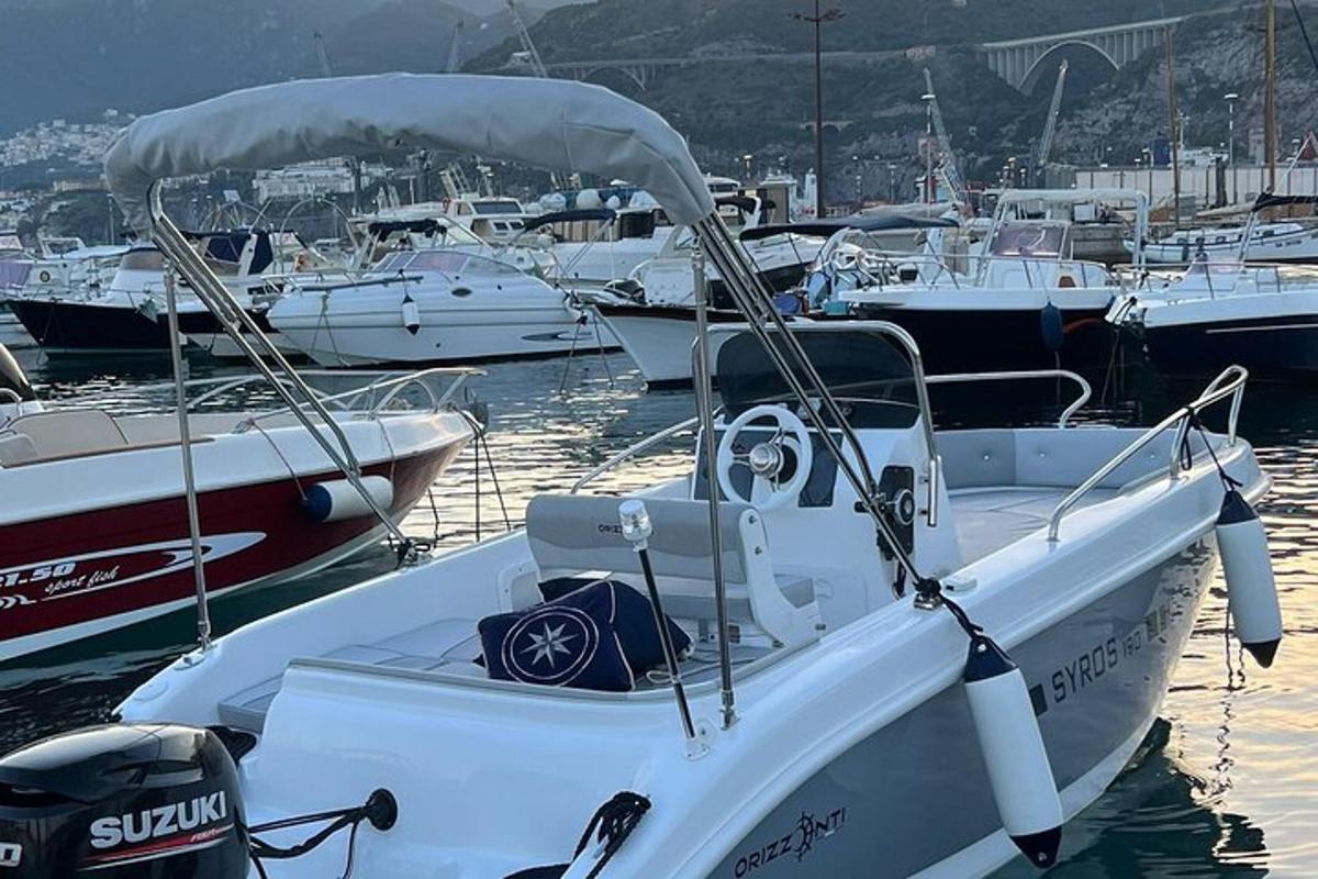 un bateau blanc garé dans une marina avec d'autres bateaux
