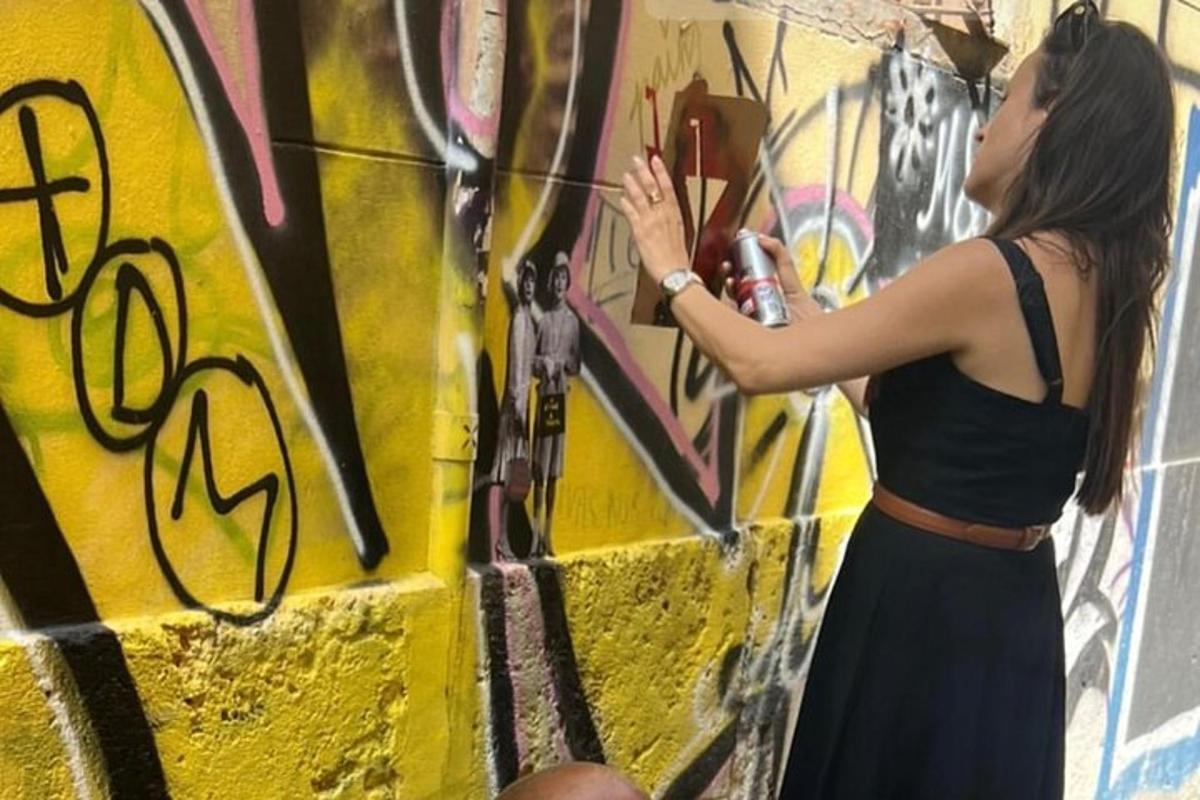una donna sta dipingendo un muro con dei graffiti