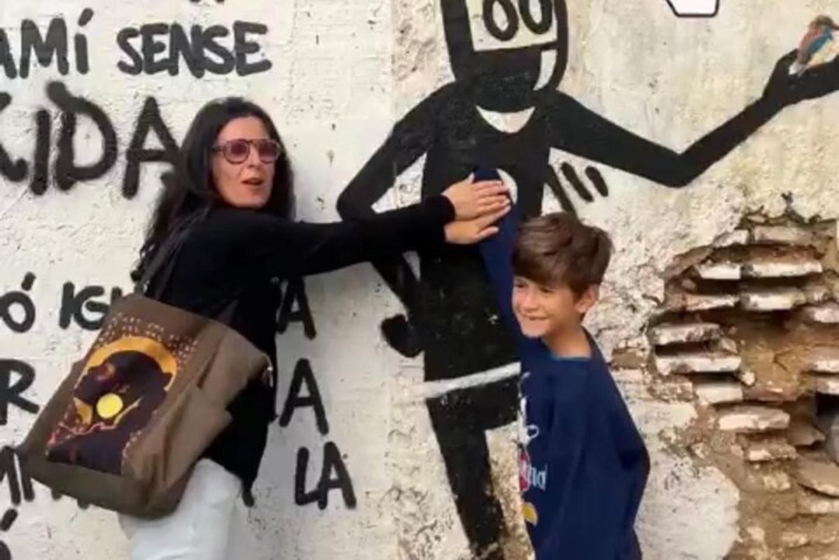 žena a chlapec stojící před zdí s obrazem