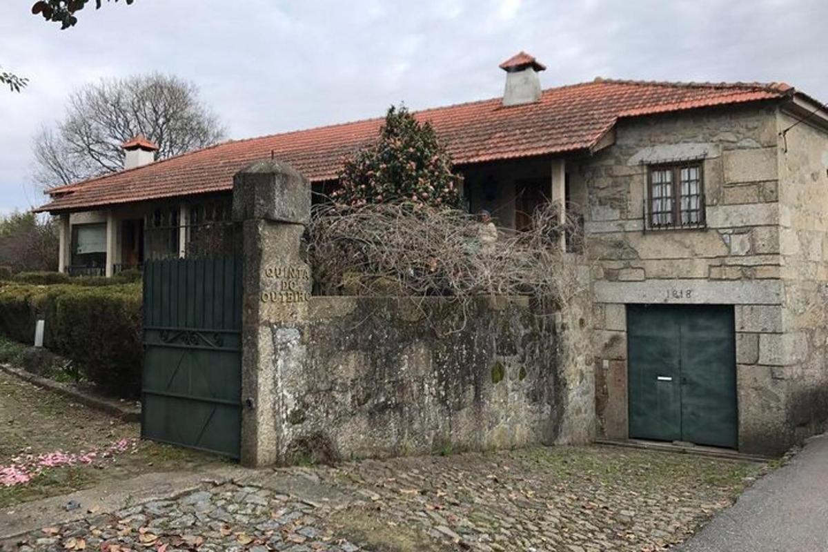 Una antigua casa de piedra con una puerta y una valla.