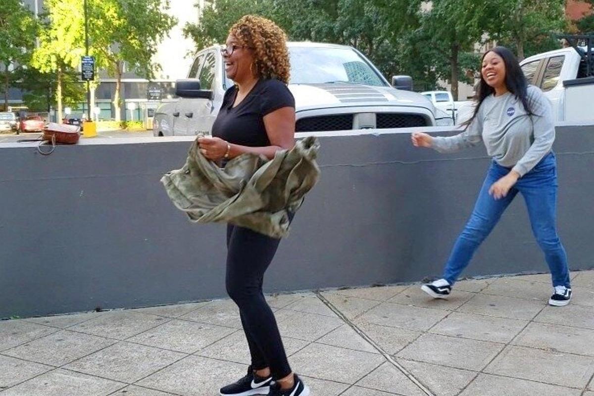 two women are standing next to a wall
