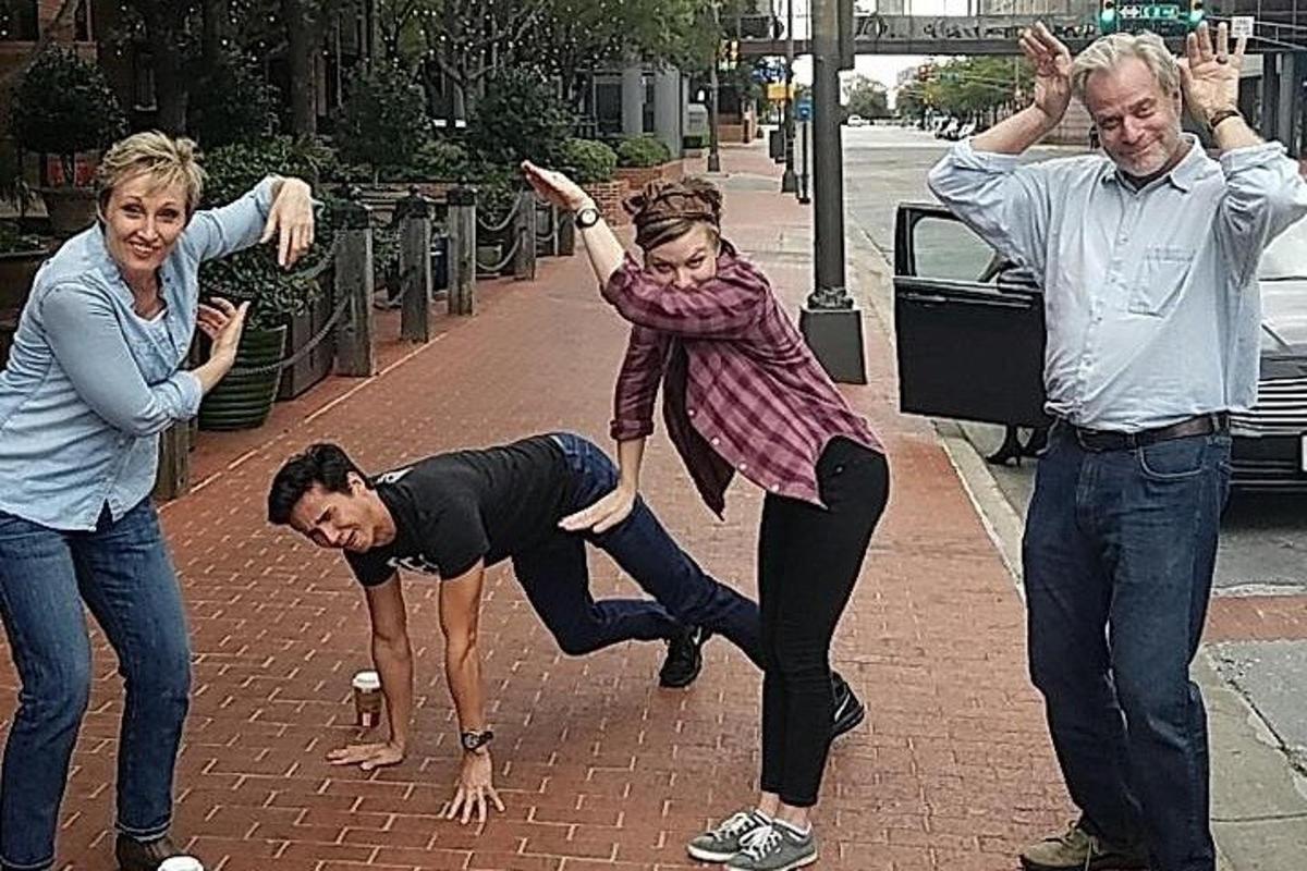 a group of people dancing on a sidewalk