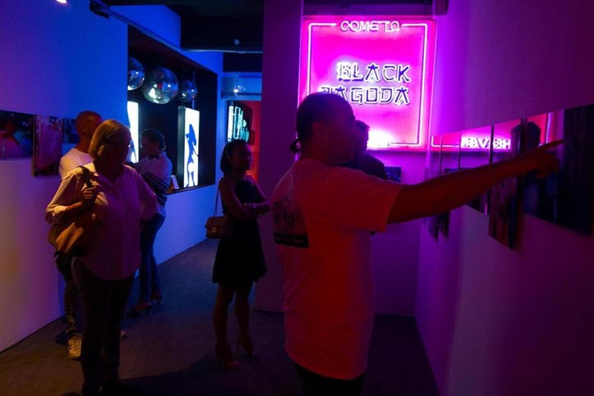 sekumpulan orang berdiri di dalam bilik dengan tanda neon