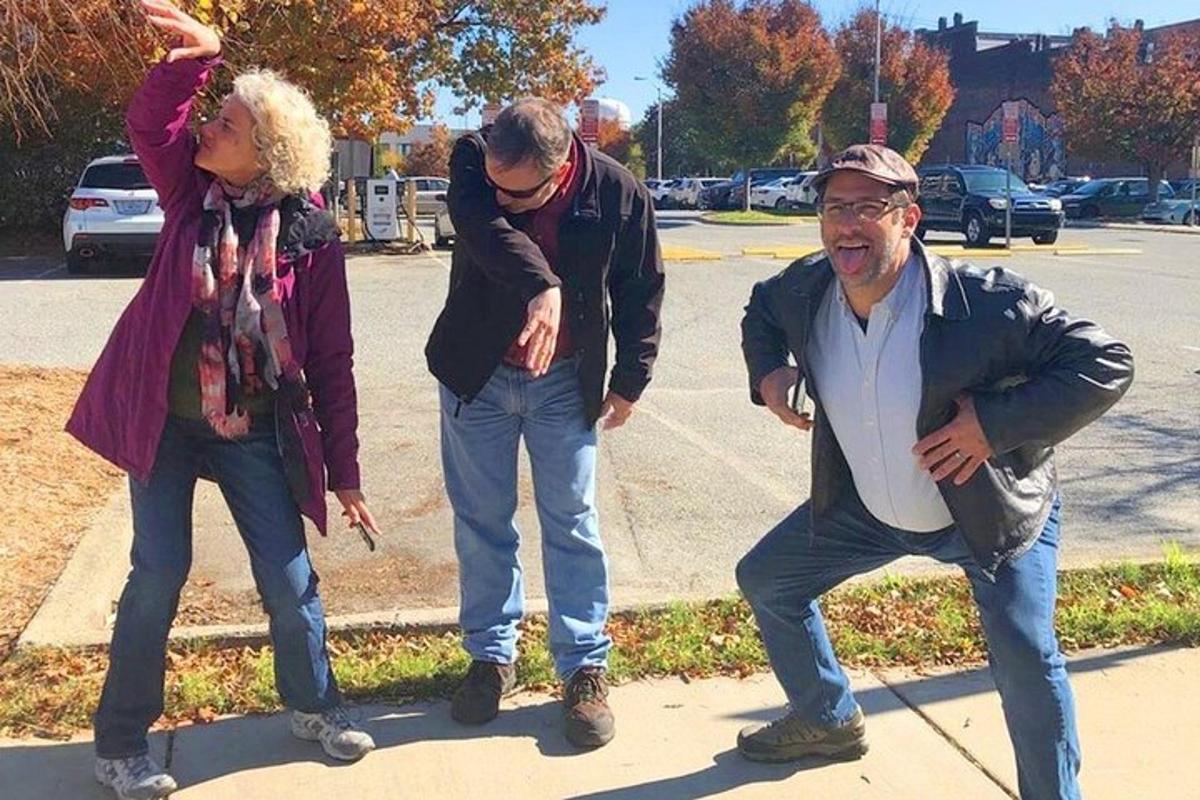 un gruppo di tre persone in piedi su un marciapiede