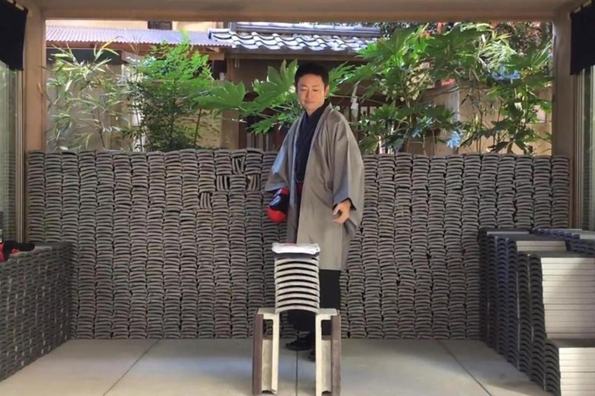 un uomo in kimono in piedi su uno sgabello