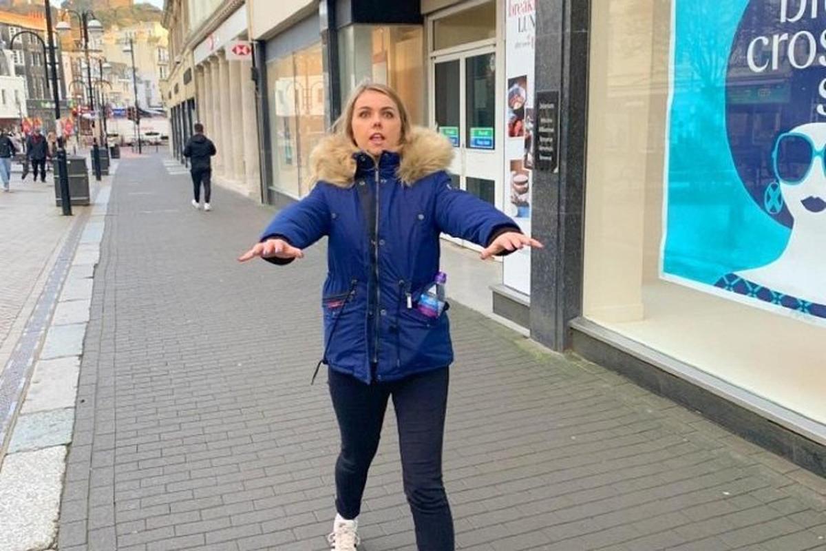 a woman walking down a street with her arms outstretched