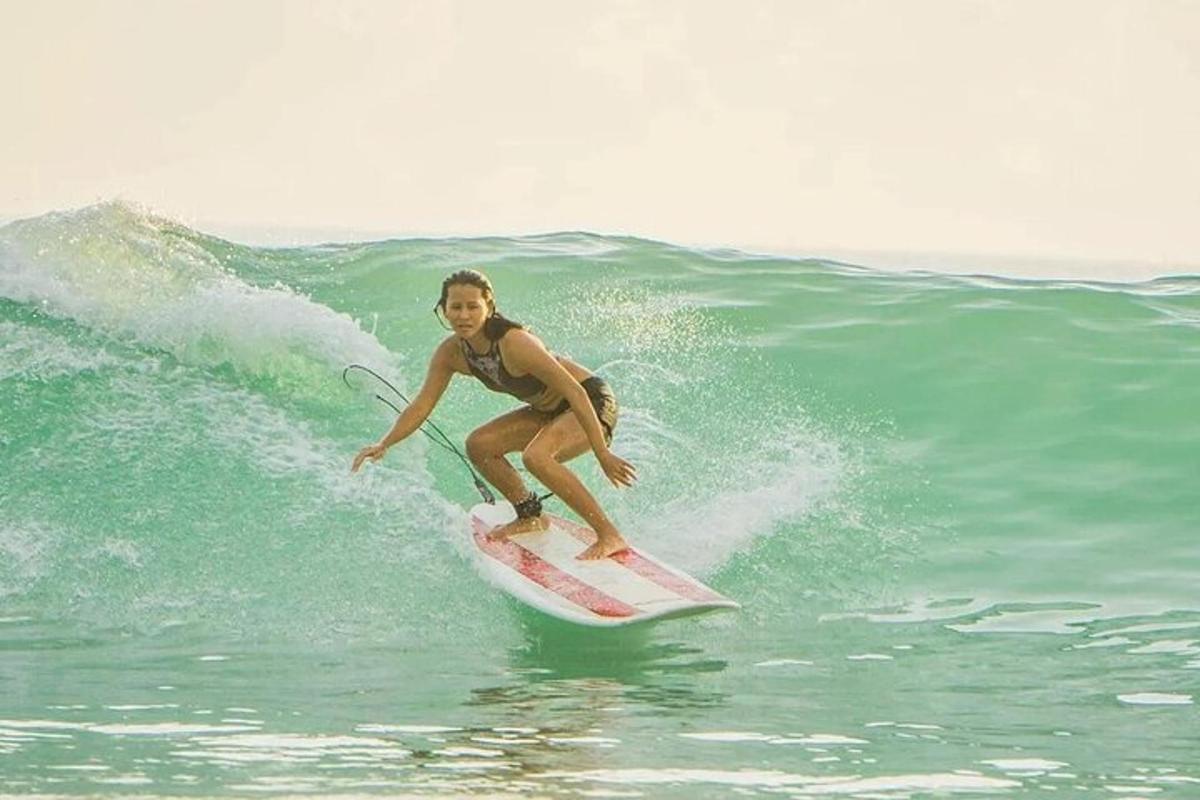 una dona cavalcant una onada sobre una taula de surf a l'oceà