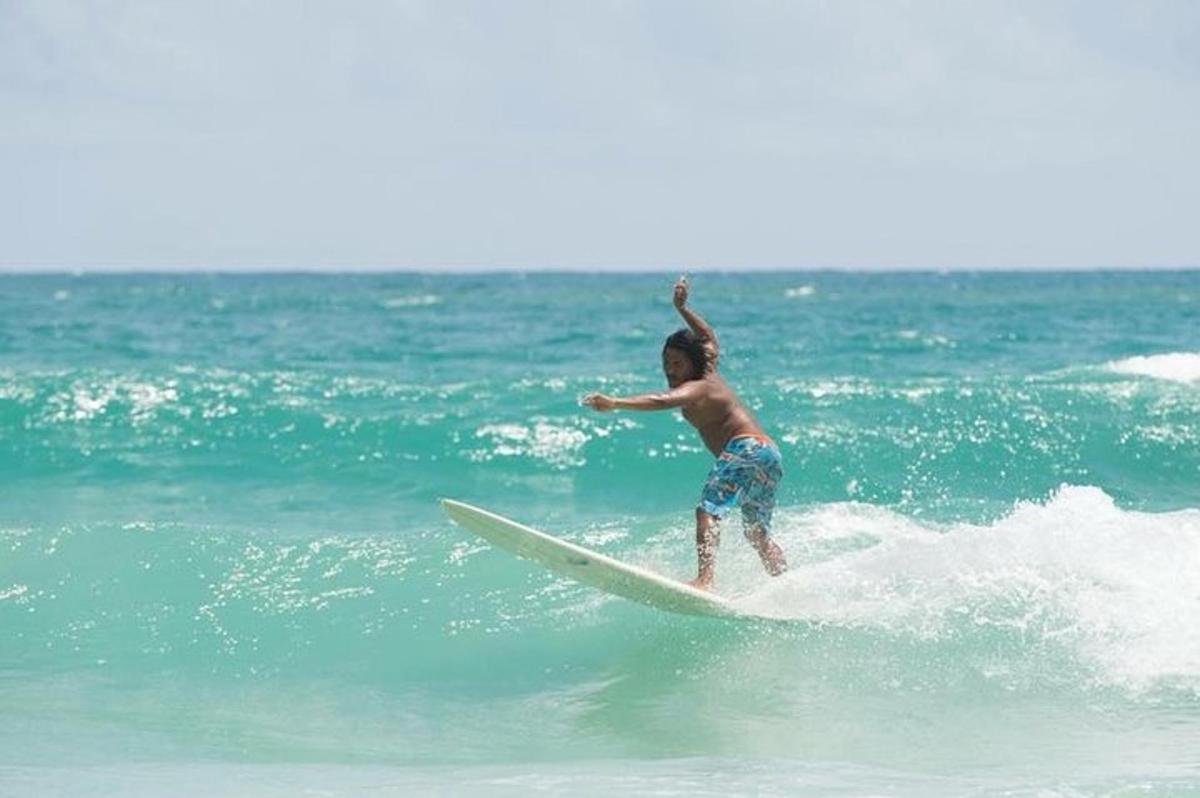 un giovane che cavalca un'onda su una tavola da surf nell'oceano