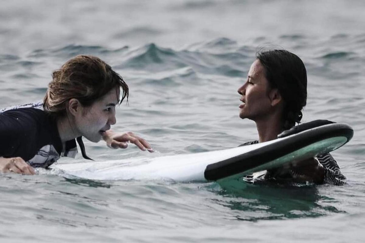 un uomo e una donna su una tavola da surf in acqua