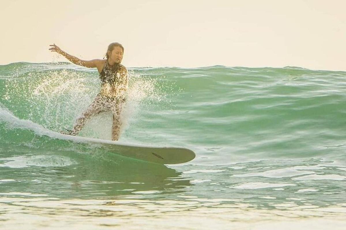 una donna che cavalca un'onda su una tavola da surf nell'oceano