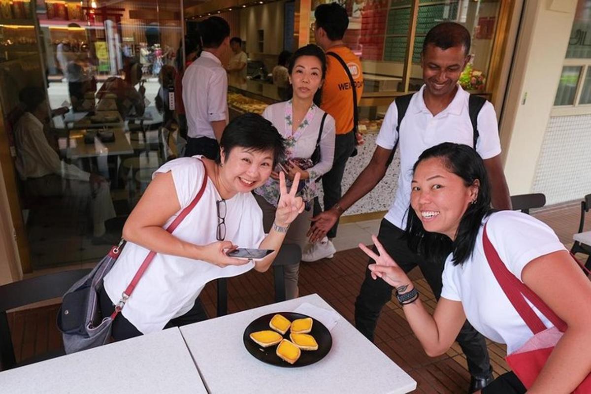 a group of people standing around a table with a cake