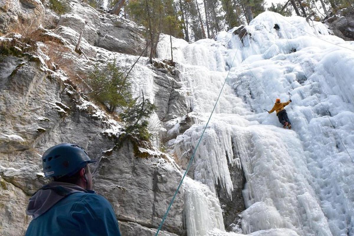 a man rappelling down a snow covered mountain