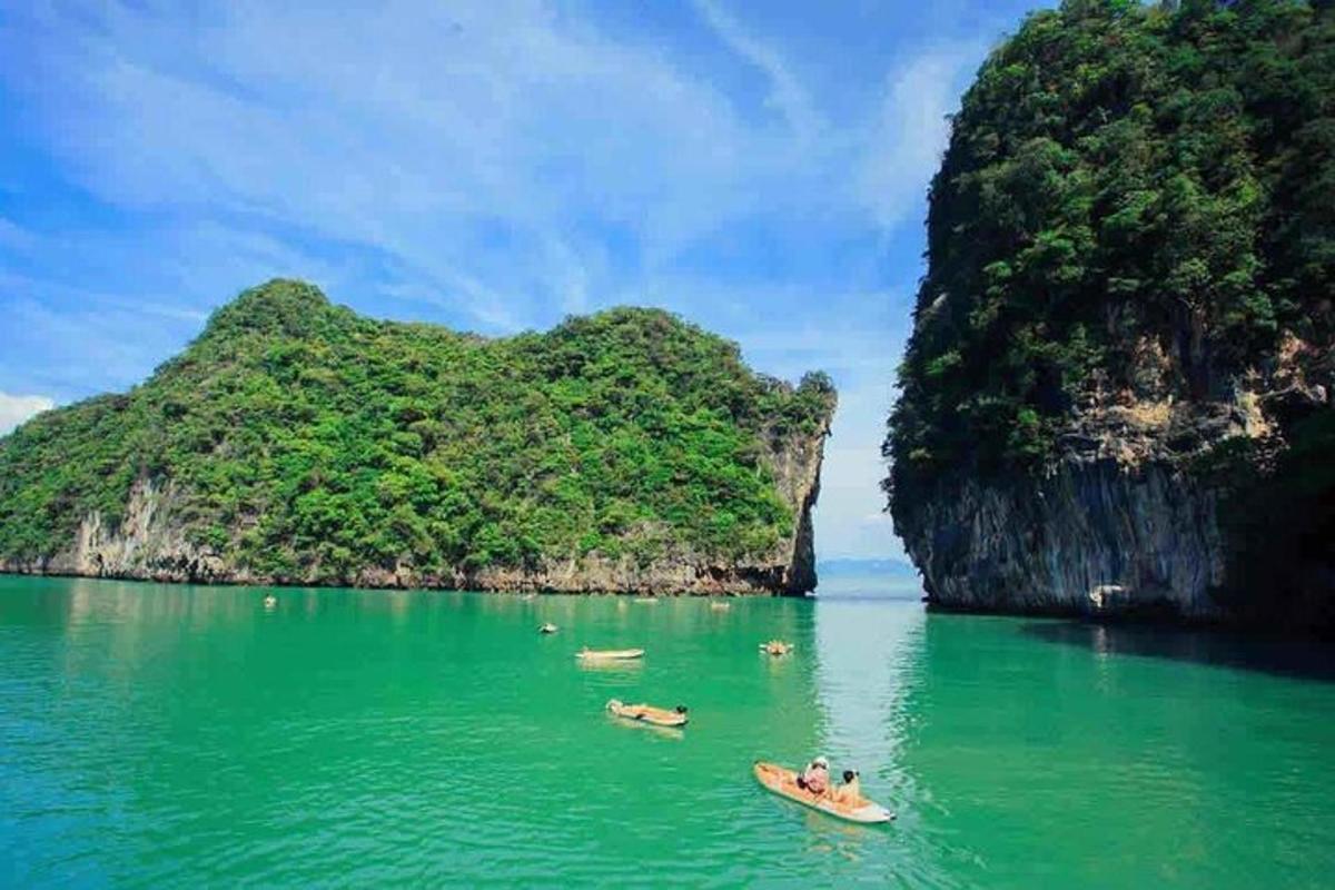 a group of people on kayaks in the water near a small island