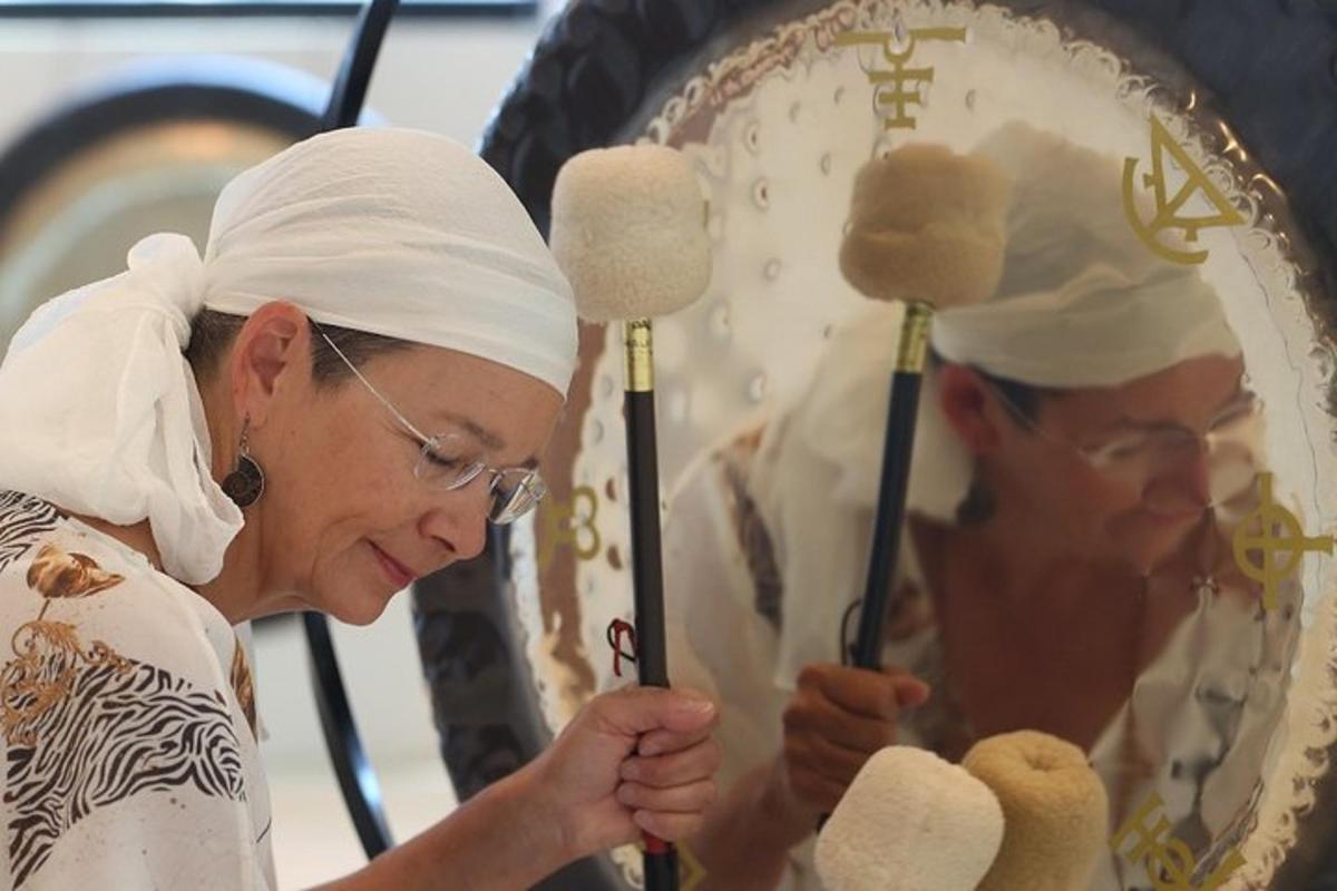 uma mulher está segurando um objeto religioso em frente a um espelho