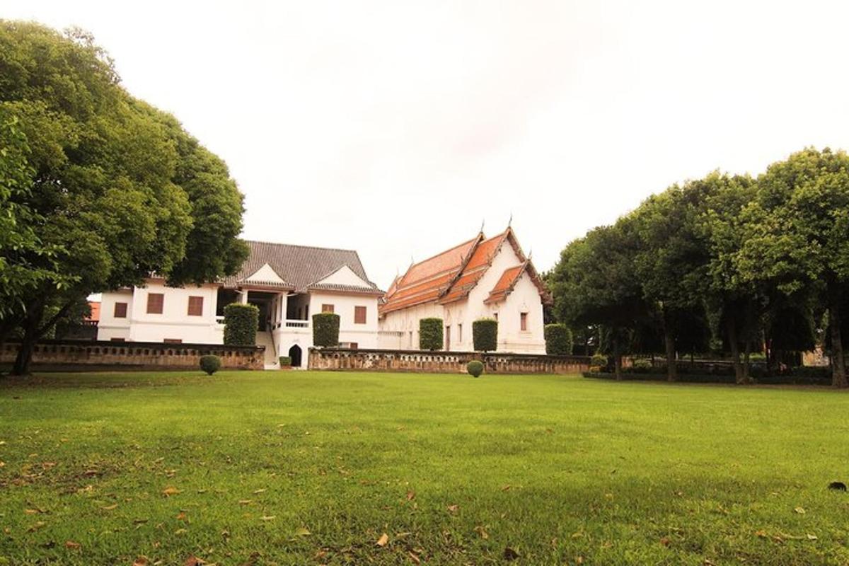a large white house with a yard with trees