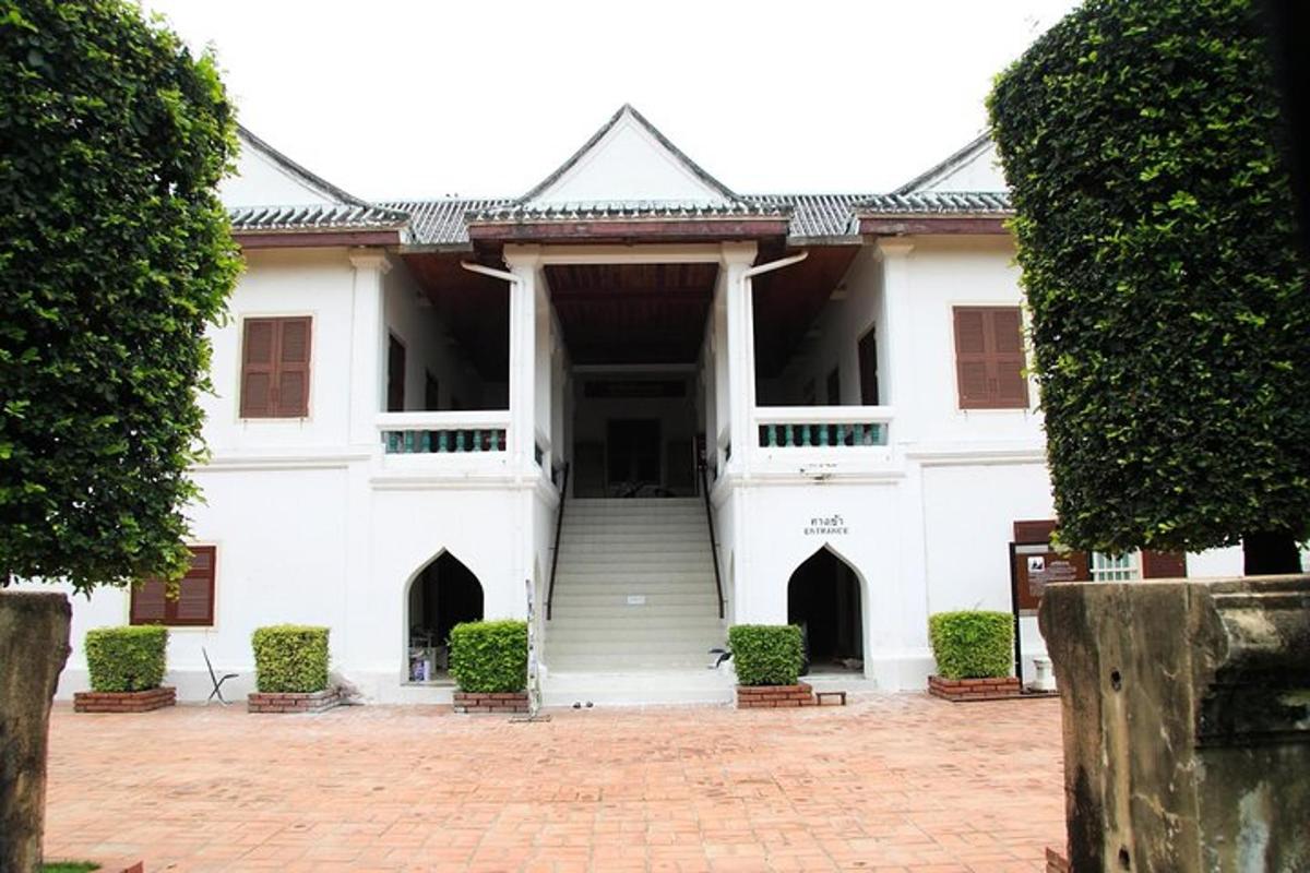a white building with a staircase in a courtyard