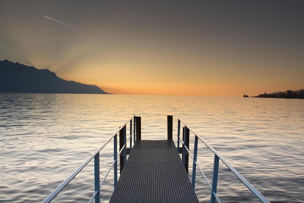 un molo sull'acqua con il tramonto sullo sfondo