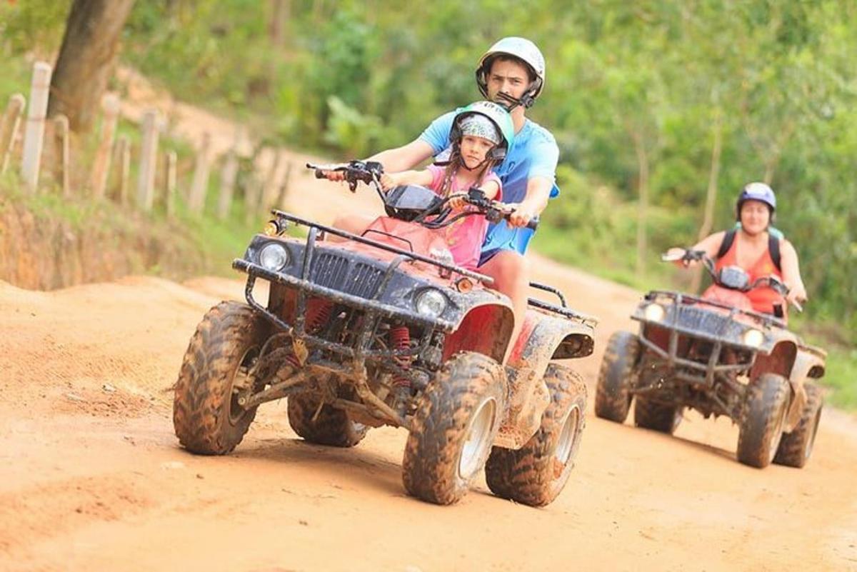 due persone in sella a quad su una strada sterrata
