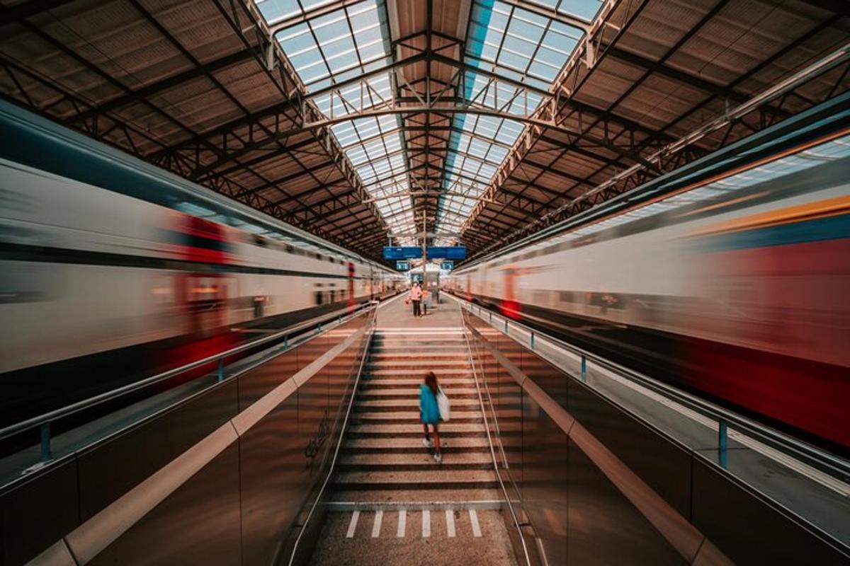 una dona caminant en una estació de metro amb dos trens