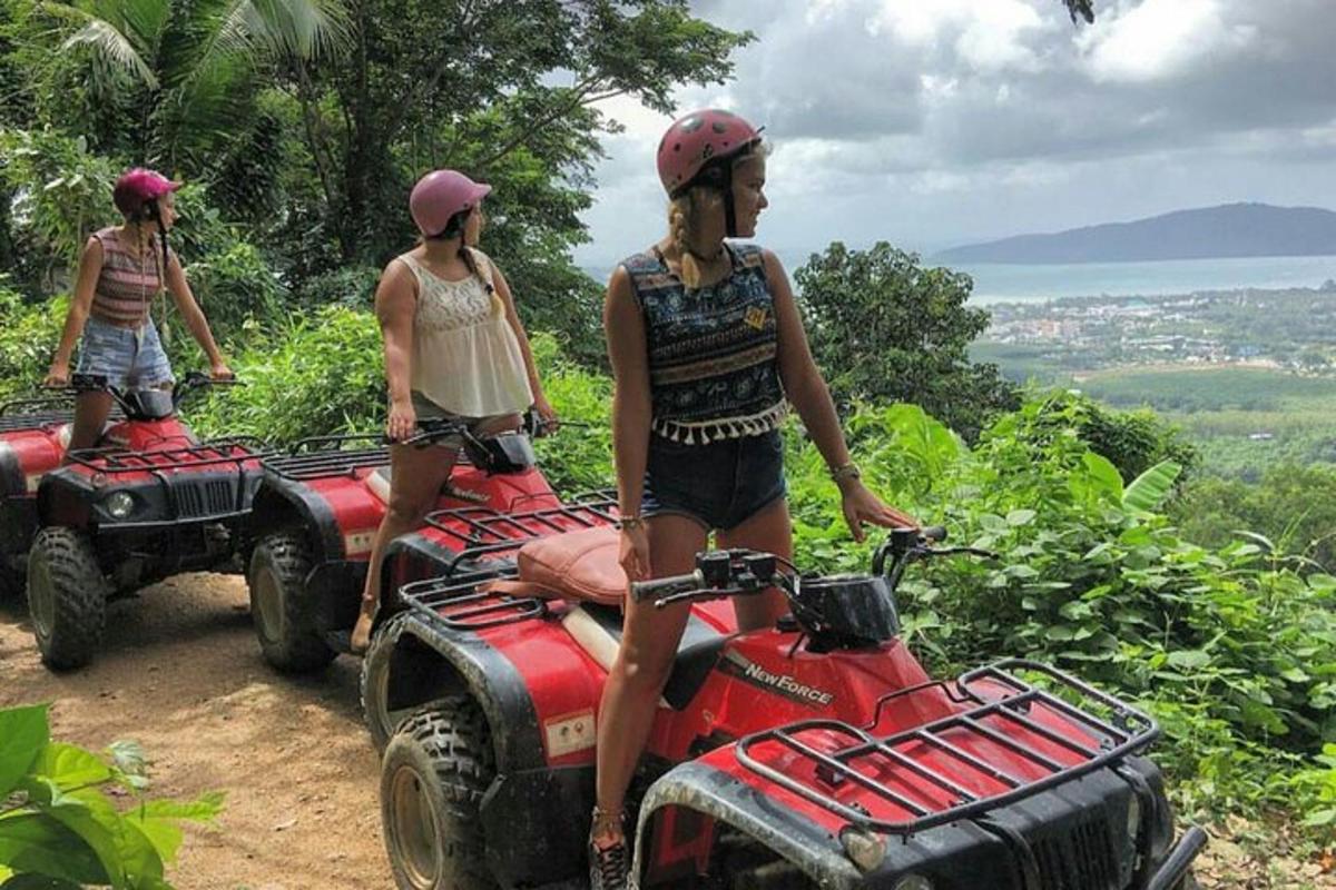 tre donne sono in piedi su dei quad su una montagna