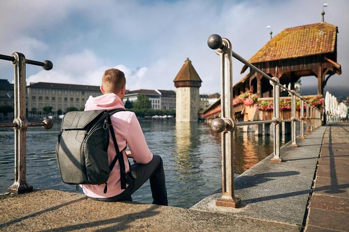 Un hombre con una mochila sentado junto al agua.