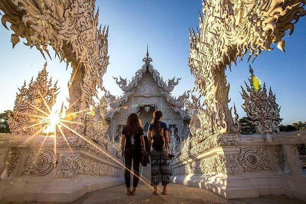 doi oameni mergând prin fața unui templu alb
