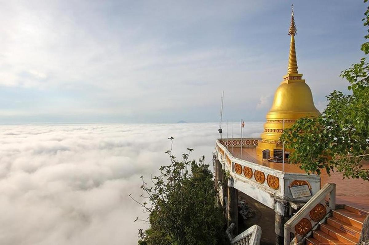 uma vista de um edifício com uma cúpula dourada nas nuvens