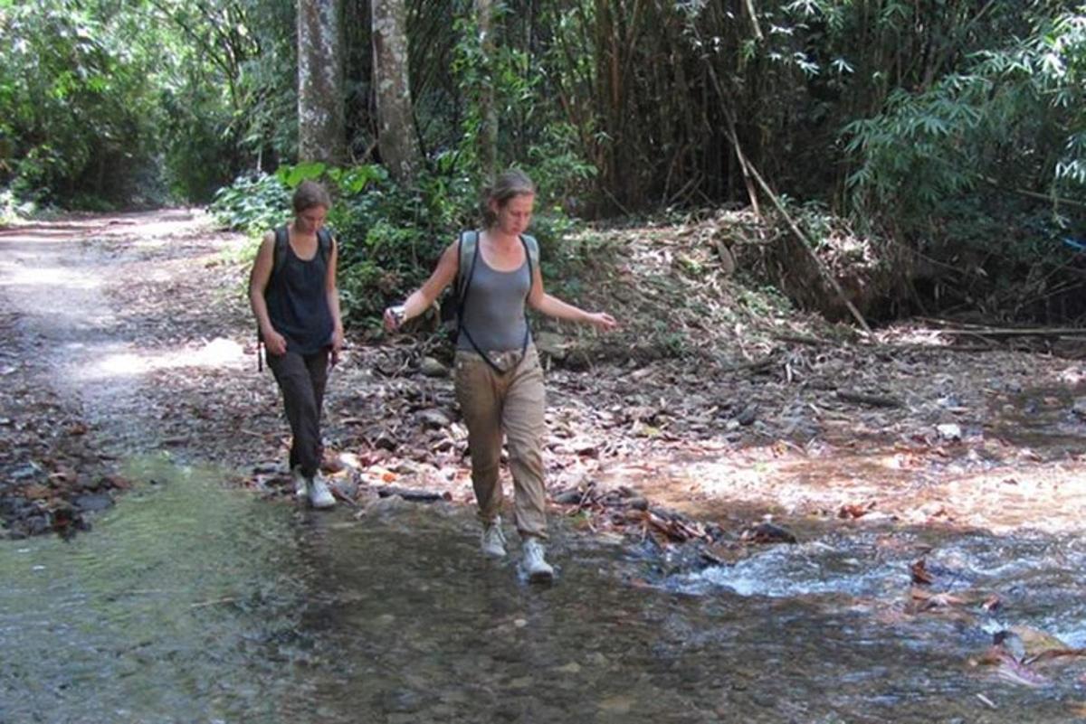 two women walking down a path in the woods
