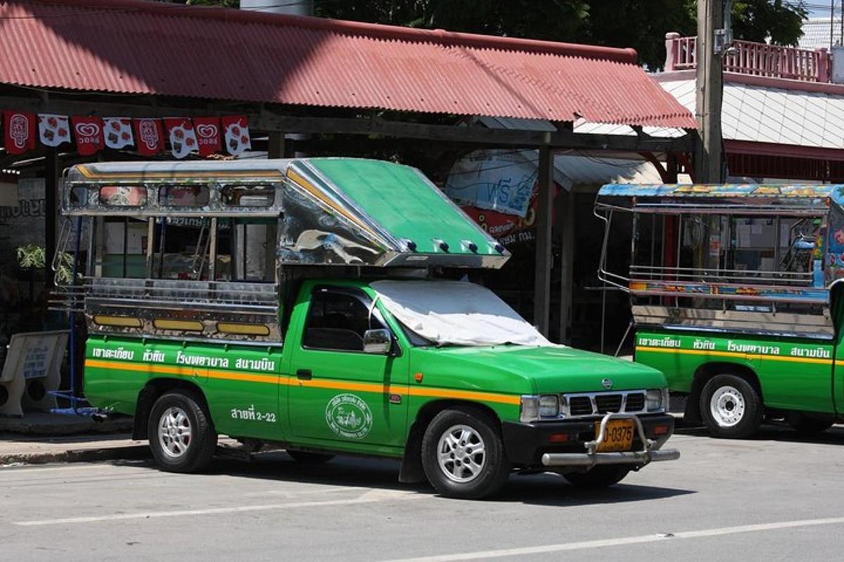 a green truck parked in front of a bus