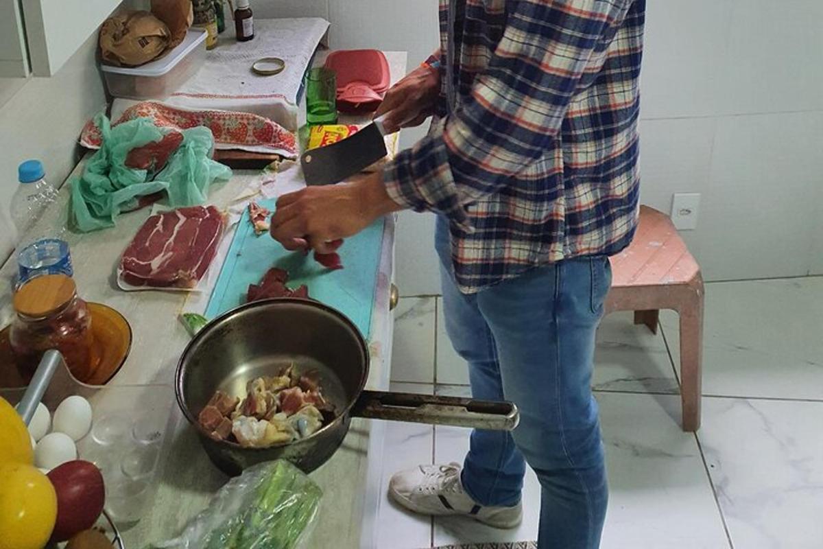 un home dret a la cuina preparant menjar