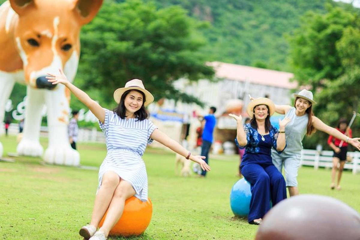 Tres mujeres con sombreros jugando con una pelota naranja con una vaca