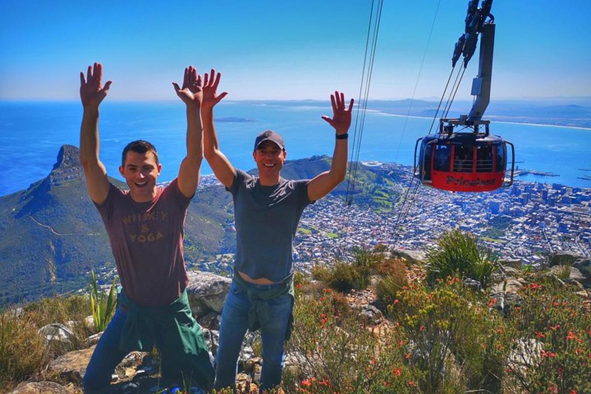 due uomini in piedi sulla cima di una montagna con le mani alzate