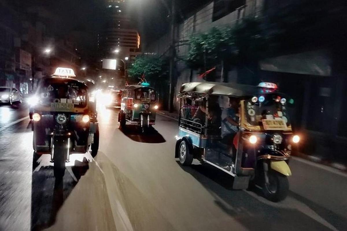 Un grupo de vehículos circulando por una calle de noche.
