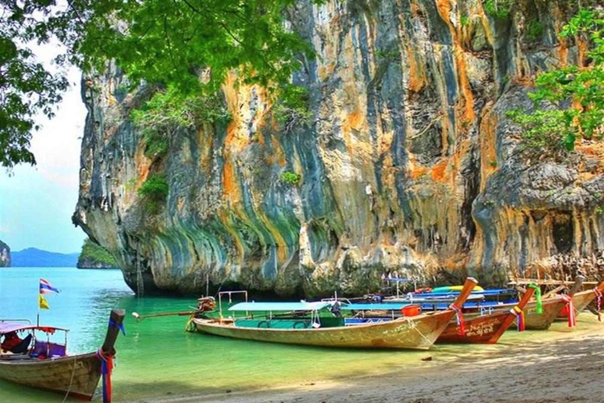 sekumpulan bot di pantai dengan pembentukan batu